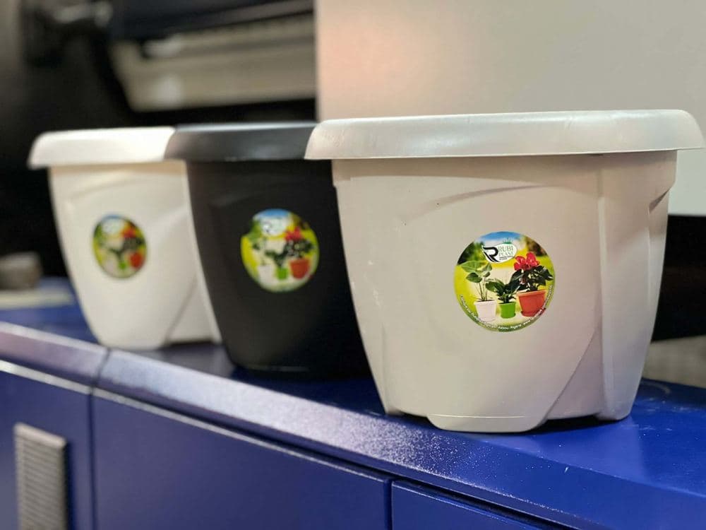 Trois pots Rubi Plast fraîchement moulés, sur la chaîne de production à Ighram